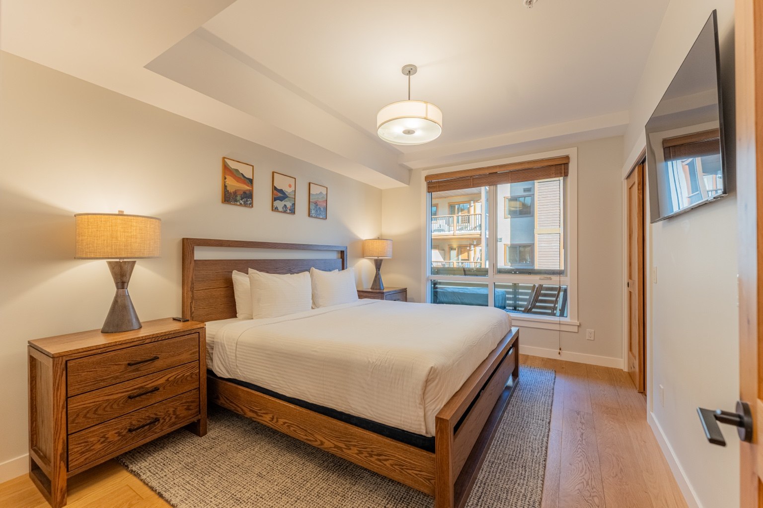 Inviting king bedroom with warm timber furnishings